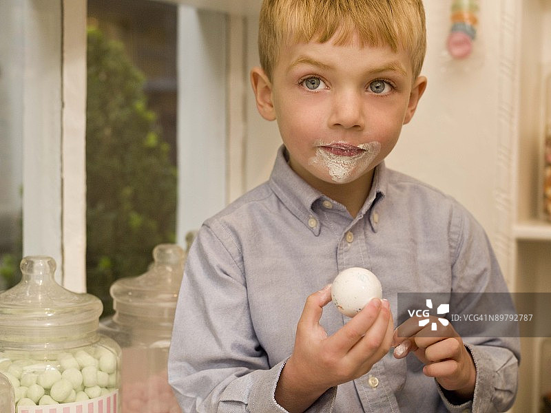 男孩在糖果店拿着硬糖图片素材
