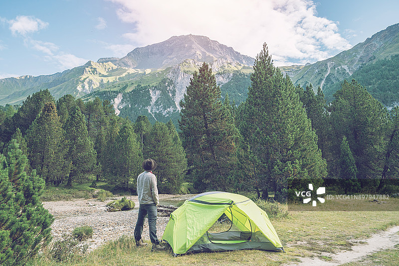 瑞士，夕阳下在帐篷旁放松的白人男子图片素材