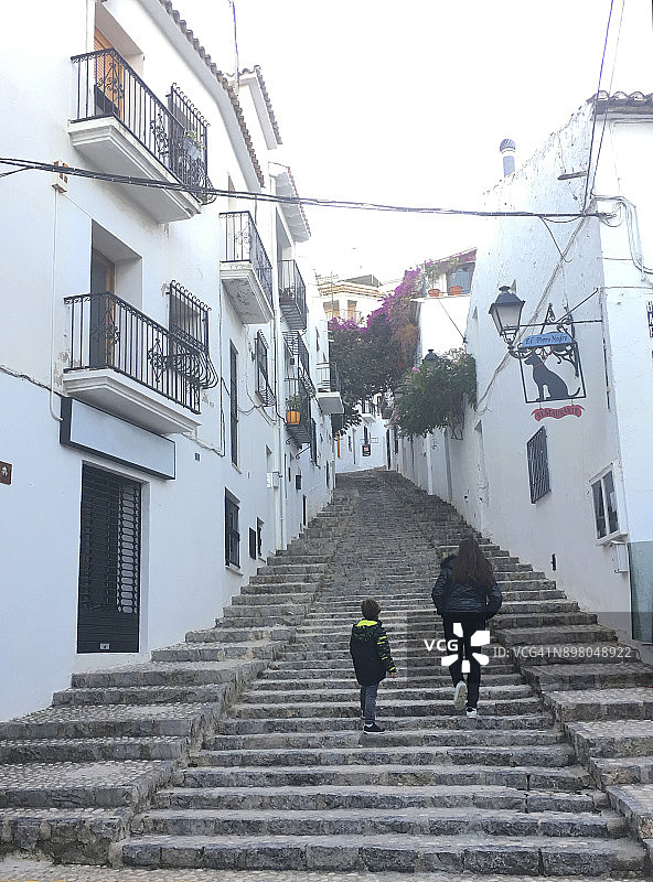 女人和男孩在街上行走图片素材