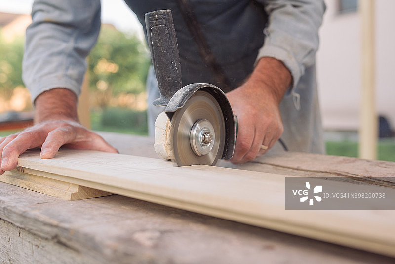 男人用手用电锯切割木板图片素材