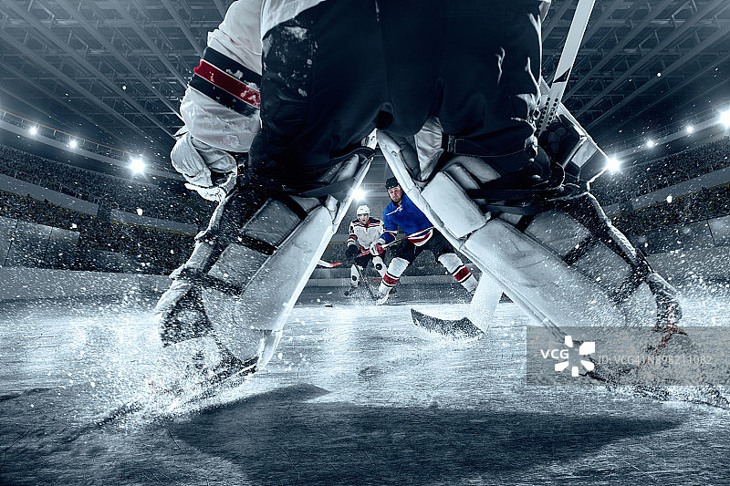 大型专业冰球场上的冰球运动员（球门视角）图片素材