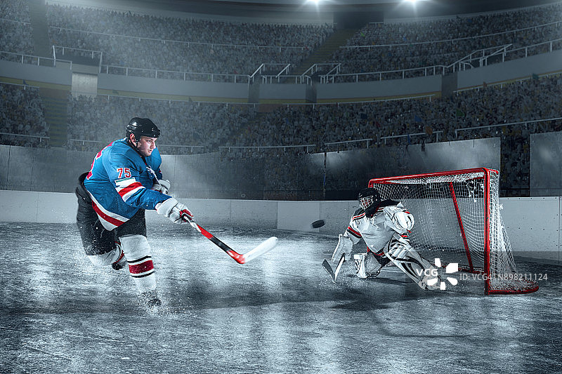 冰球运动员在大型专业冰场上射门得分图片素材