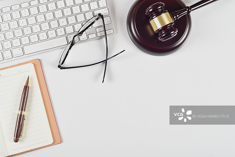 律师事务所桌面：电脑键盘，法官木槌和文件图片素材