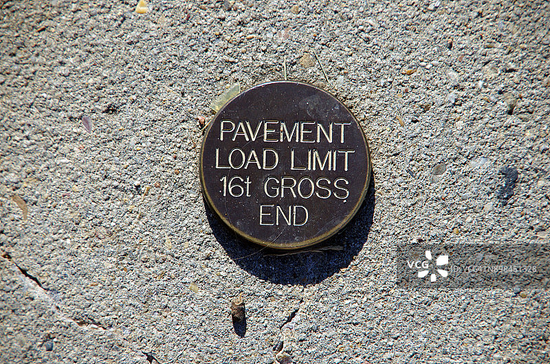 青铜金属标志，指示混凝土人行道上的路面载荷限制为16总吨图片素材