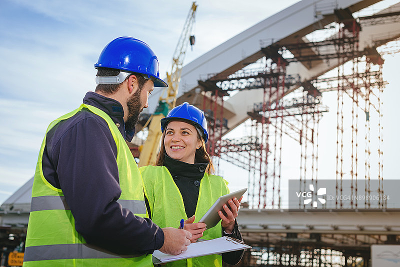 工程师们在建筑工地一起工作，使用蓝图和计划图片素材