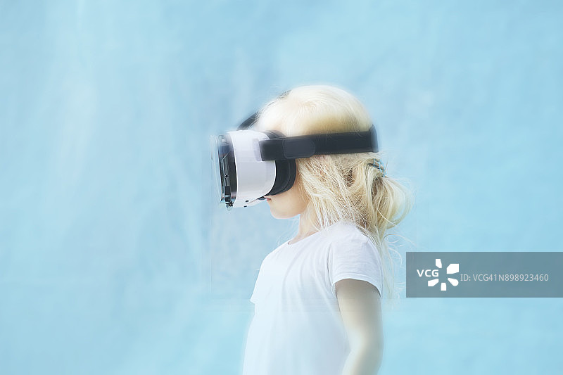女孩使用VR眼镜的侧视图，模糊效果图片素材