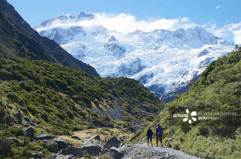 在Mount Sefton山和相邻雪山前的Kea Point Track上的徒步者图片素材