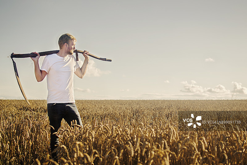 手持镰刀的年轻农民图片素材