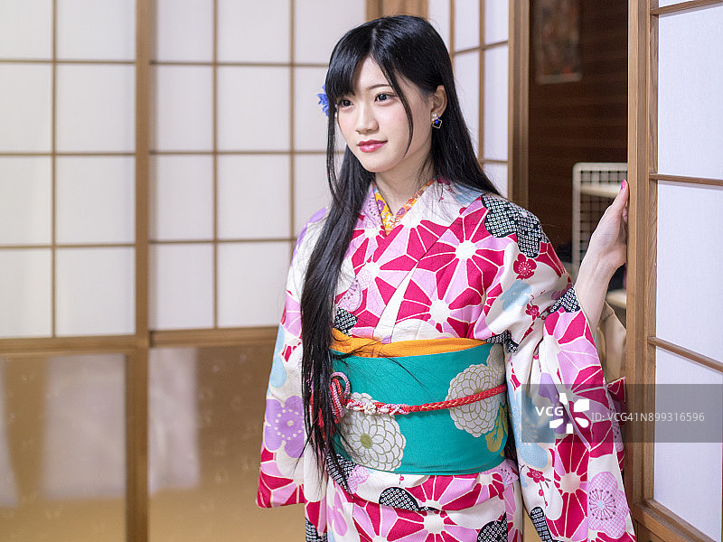 身穿和服进入日式榻榻米房间的年轻女人图片素材