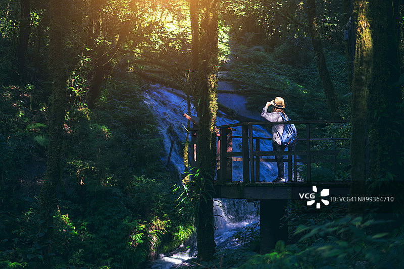 年轻女人在茵他侬山国家公园Kew Mae Pan自然步道旅行，欣赏美丽的瀑布，泰国清迈图片素材