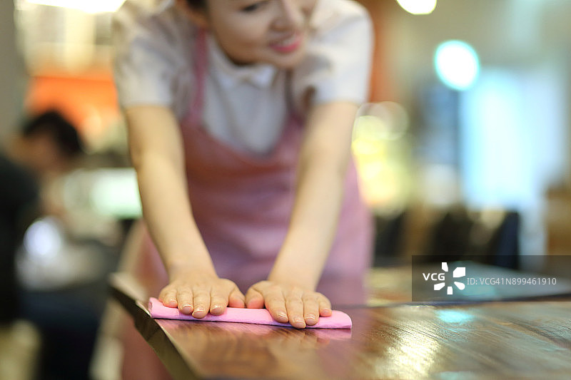 女服务员在咖啡馆擦拭桌子图片素材