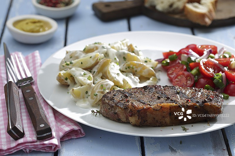 臀肉牛排配土豆沙拉和番茄沙拉图片素材