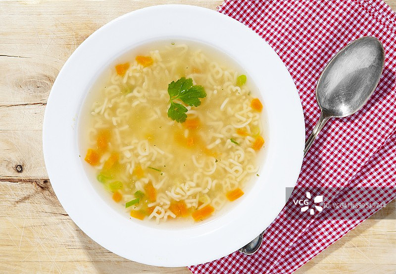 一碗字母汤，木质表面有勺子图片素材