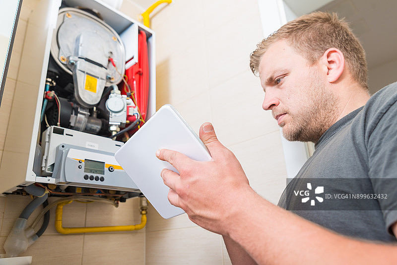 技术员使用数位板修理燃气炉图片素材