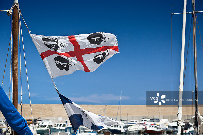 卡斯特尔萨多渔港的撒丁岛旗帜与蔚蓝天空图片素材