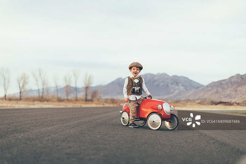 驾驶玩具车的年轻复古男孩图片素材