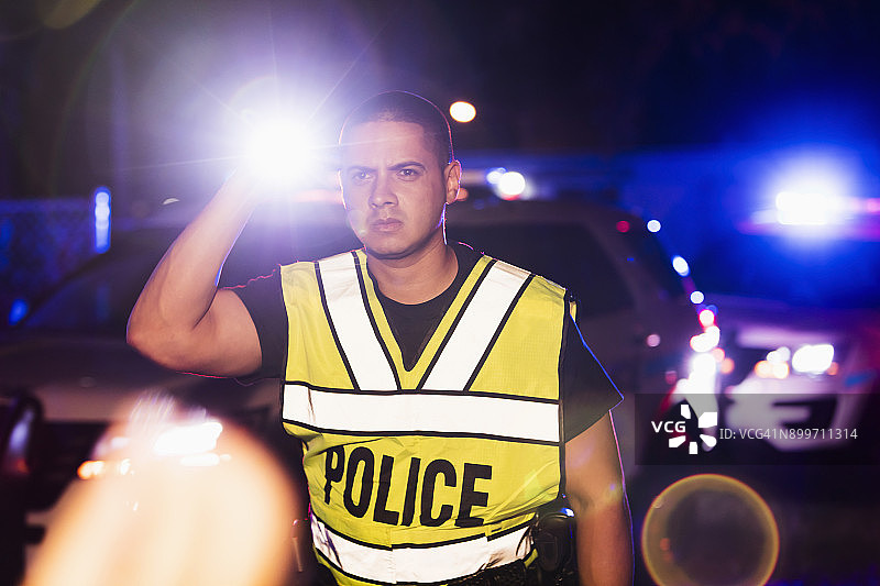 西班牙裔警察在夜晚，闪烁着灯光图片素材