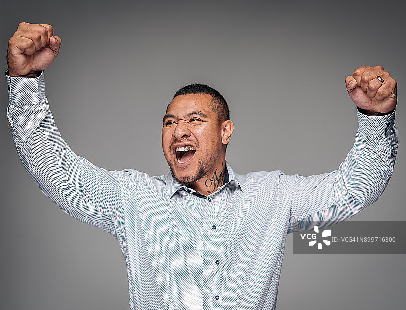 在工作室里举起双臂的英俊毛利男子肖像图片素材