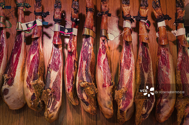 西班牙火腿悬挂在巴塞罗那博盖利亚市场图片素材