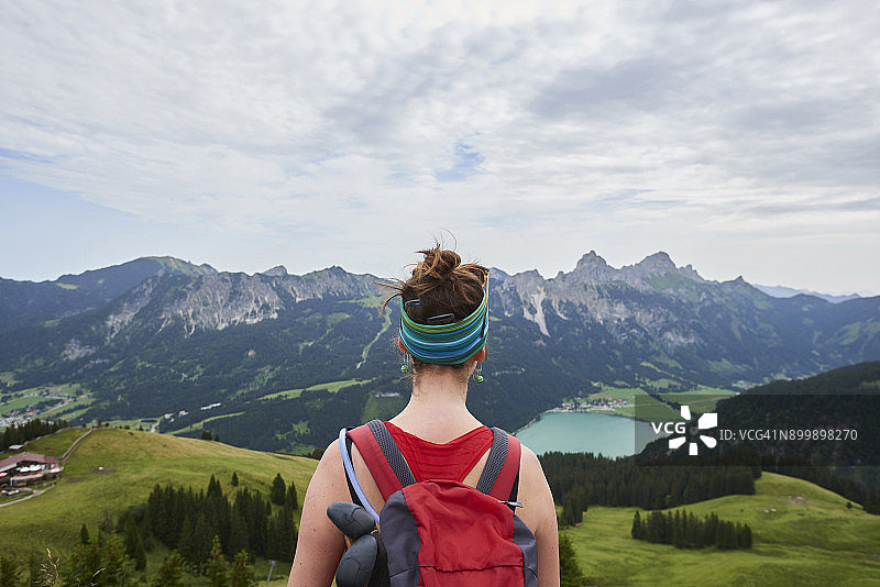 在奥地利蒂罗尔州坦海姆山脉，眺望山谷的女性徒步旅行者背影图片素材