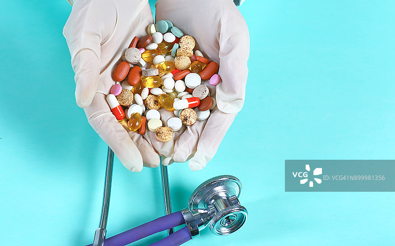 女医生在工作场所手持不同药片图片素材
