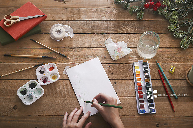 年轻女子用铅笔绘制圣诞贺卡，顶视图图片素材