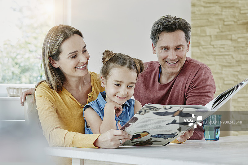 幸福的家庭在家看图画书图片素材