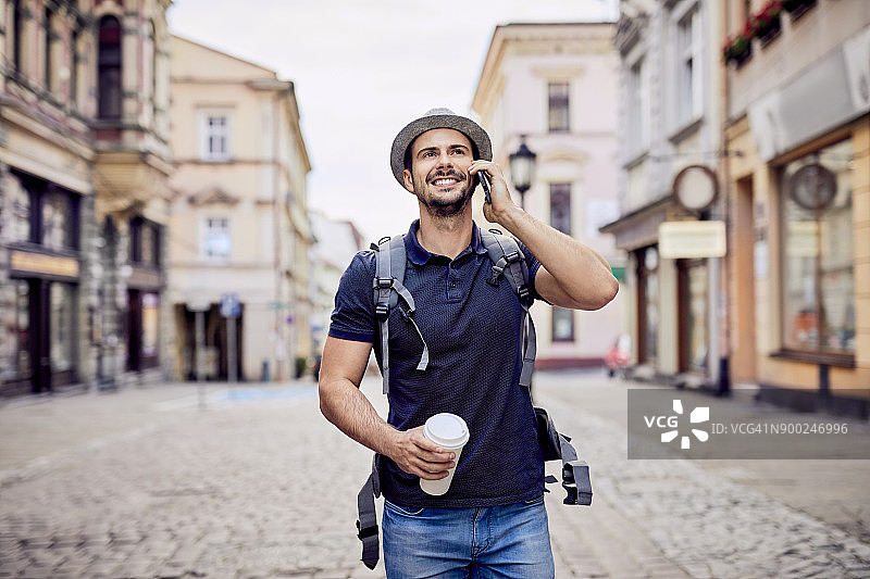 旅行者在城市街道上边走边打电话图片素材