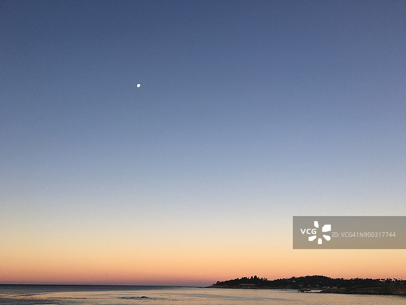 日出时分的海景，极简风格，月亮悬挂于海平面之上图片素材