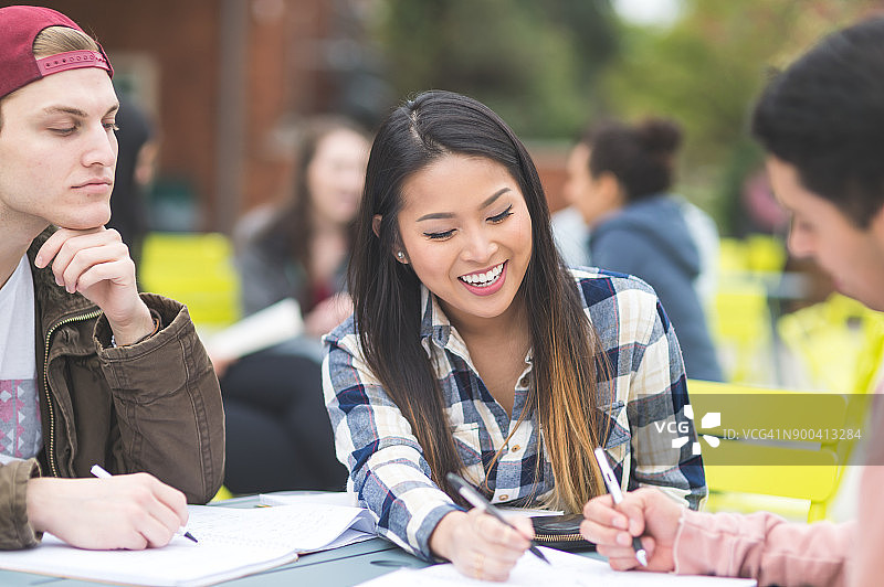 大学生在室外课桌旁一起学习图片素材