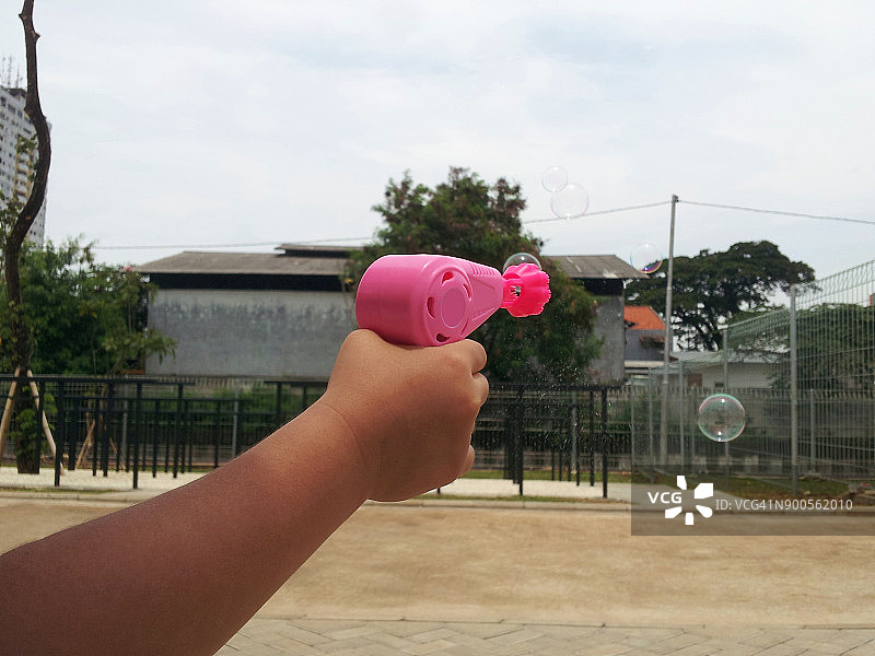 小女孩玩吹泡泡枪图片素材