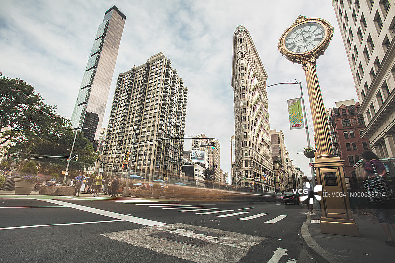 无法辨认的人群和车辆经过纽约市熨斗大厦图片素材