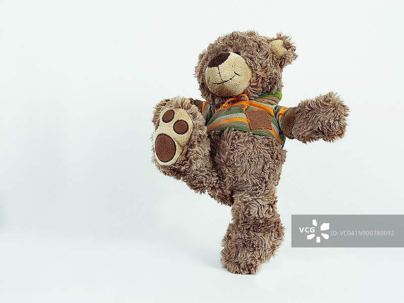 棕色毛绒熊踢腿图片素材