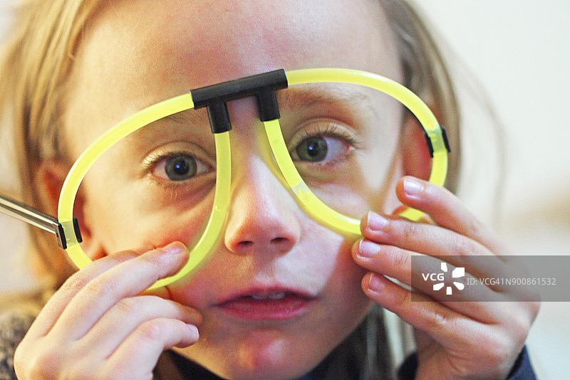 戴着荧光派对眼镜的五岁女孩图片素材