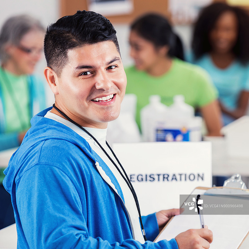 在健康博览会上登记做志愿者的西班牙裔男人图片素材