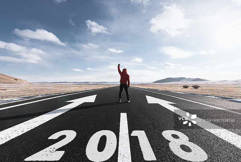 男人站在绘有2018字样的长路上图片素材