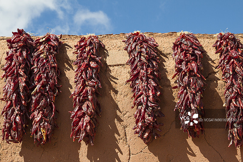 土坯墙上的红色辣椒串图片素材