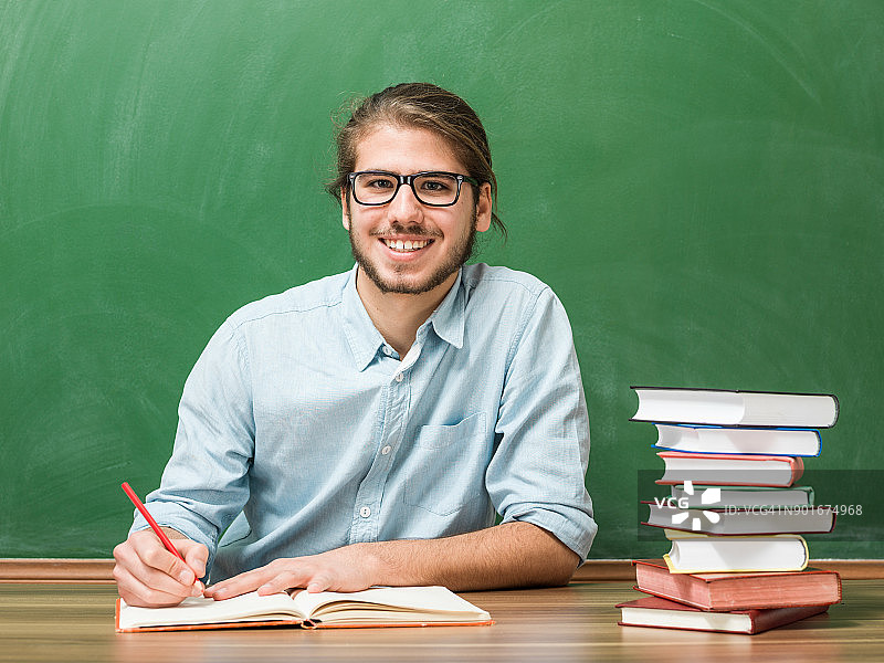 站在绿色黑板前的成年学生图片素材
