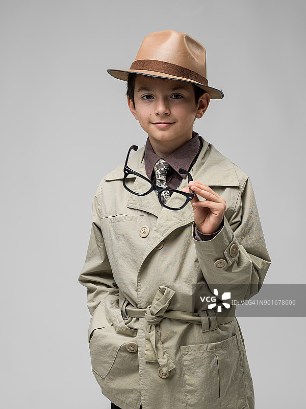 穿着风衣和戴眼镜的考究小男孩图片素材