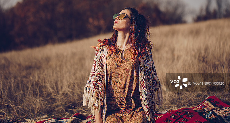 坐在田野里的嬉皮风格美女图片素材