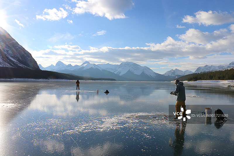 日出时分在湖上钓鱼的两位渔民图片素材