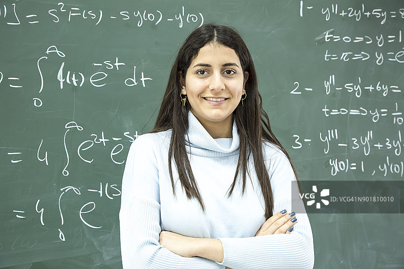 女学生在黑板前书写数学公式图片素材