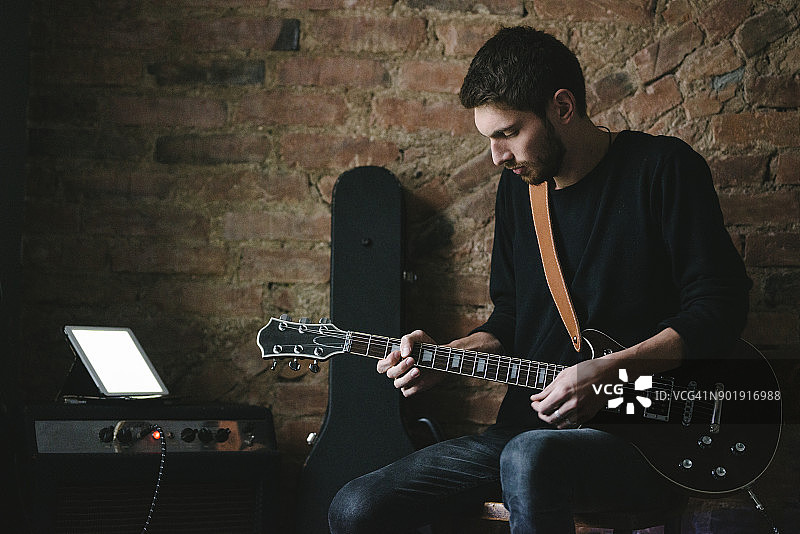 吉他手用平板在放大器上弹吉他图片素材