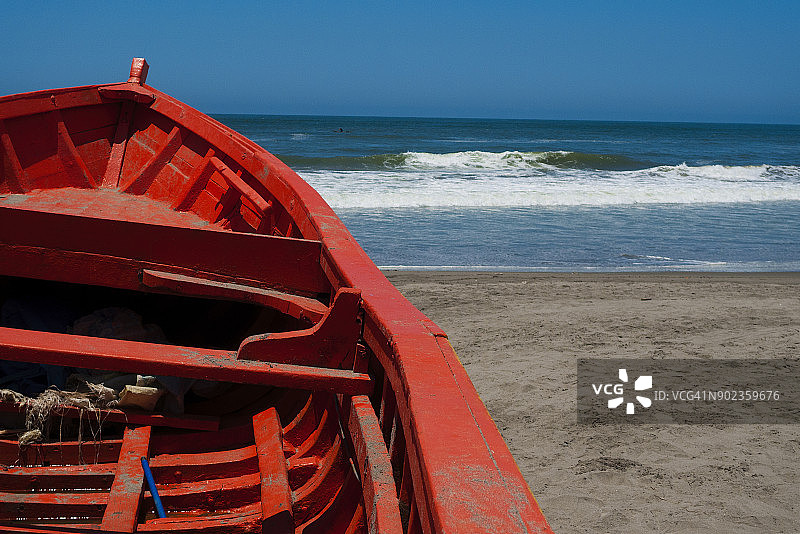 搁浅在海滩边缘的红色船图片素材