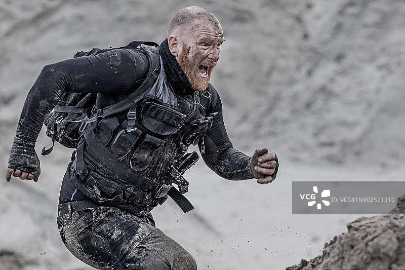 在沙丘上努力训练的红发光头男性军人图片素材