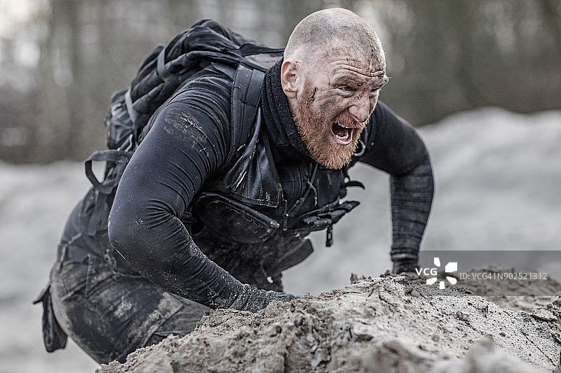 在沙丘上努力训练的红发光头男性军人图片素材