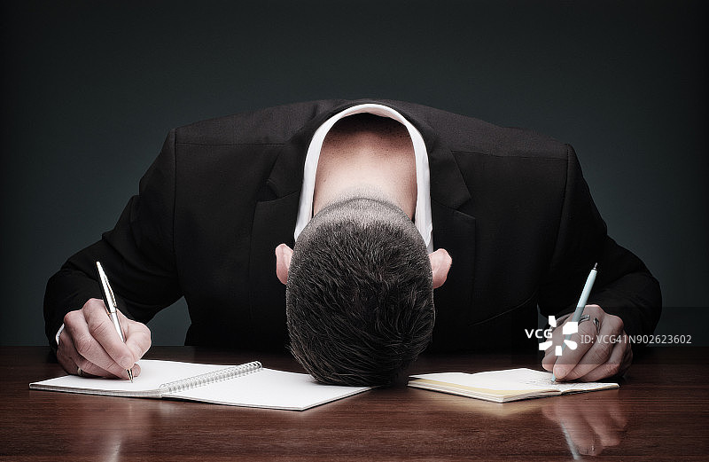 过度劳累的男人在写作时倒下图片素材