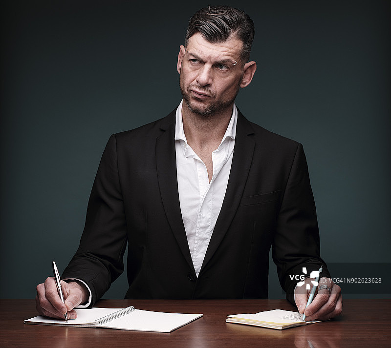 工作过度的作家同时使用两个笔记本图片素材