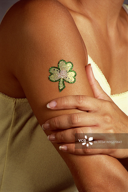 手臂上有三叶草纹身的女人图片素材