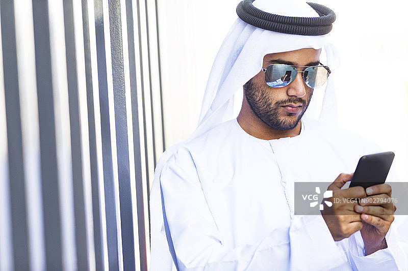 在户外使用手机的年轻阿拉伯人图片素材